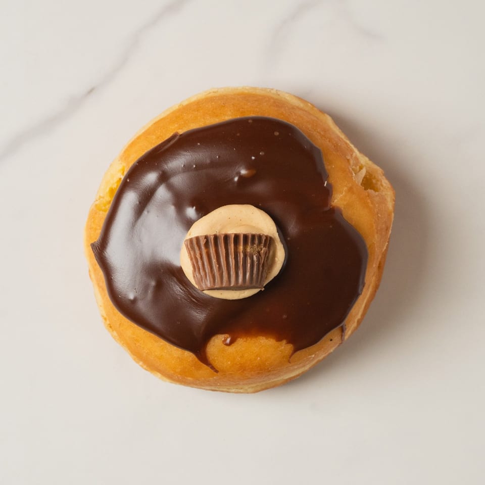 A peanut butter cup donut from Elmwood Pastry Shop, topped with chocolate frosting and a mini Reese's.